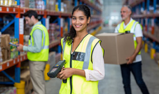 bipoc woman wearing reflective vest in a warehouse